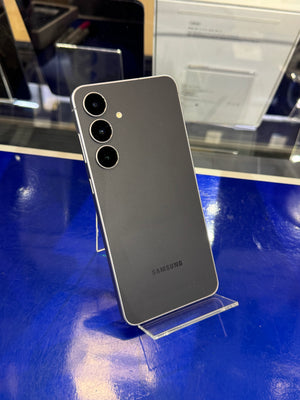 Samsung smartphone on a stand with a blue surface in the background
