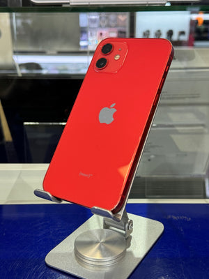 A red Apple iPhone shown from the back and mounted on a silver display stand against a blue and glass background.