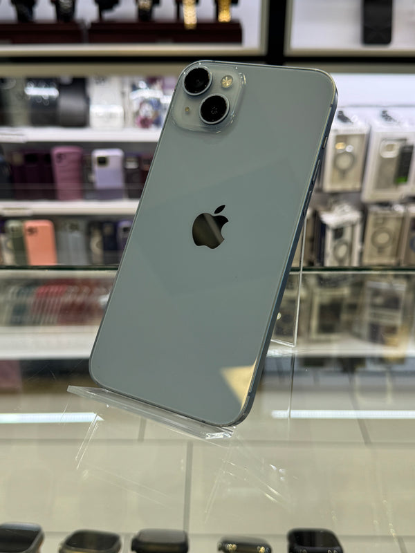 Silver iPhone 11 Pro Max held against a blurred store interior background