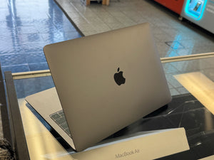 MacBook Air on display with Apple logo on a glass surface
