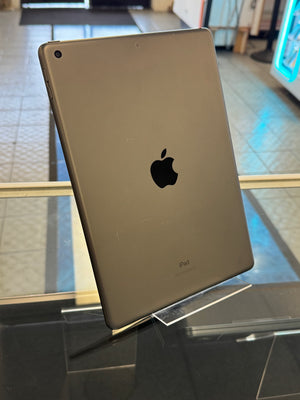 Back view of a gold Apple device with Apple logo on a reflective surface