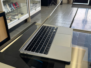 Laptop on a glass table with a blurred store interior in the background