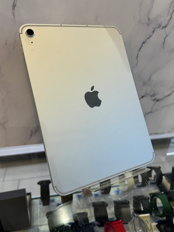 A silver Apple iPad with a glossy back, shown from the rear with the Apple logo visible, resting on a display stand in a retail setting.