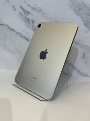 An iPad standing upright on a clear acrylic display stand against a white marble-patterned background.