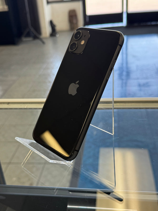 Black smartphone with Apple logo held up against a blurred indoor background