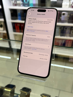 Smartphone displaying battery health menu on a reflective surface with blurred background