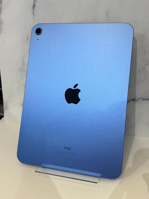 Blue iPad back view standing on a clear display stand against a light marble-patterned background.