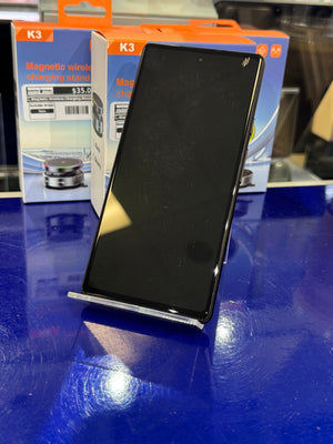 Smartphone on a blue surface with packaging in the background