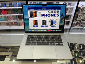 Laptop displaying a phone store website on a glass surface with a store background.