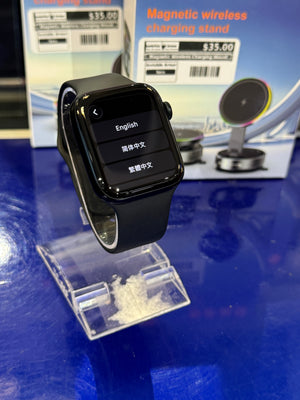 Smartwatch on a clear stand with a magnetic wireless charging stand in the background
