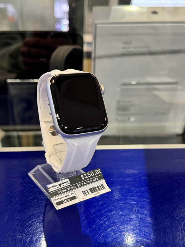 White smartwatch on a blue display stand with a price tag in an indoor setting.