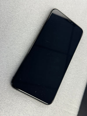 A black smartphone with a glossy screen, shown from a top-down angle on a light gray textured surface.