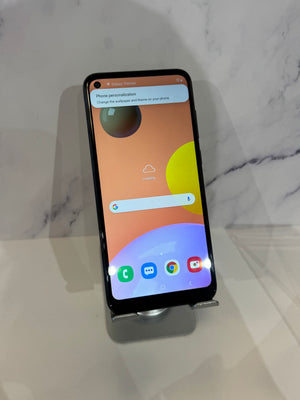 A Samsung Galaxy smartphone displayed upright on a small stand against a light marble-patterned background.