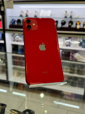 Red smartphone with Apple logo on a stand in a store setting