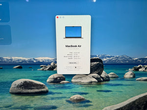 Product display of MacBook Air with a scenic background of mountains and water.