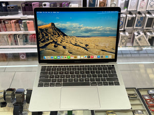 Laptop on display in a store with a desert landscape on the screen