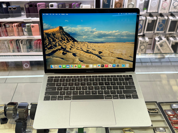 Laptop on display in a store with a desert landscape on the screen