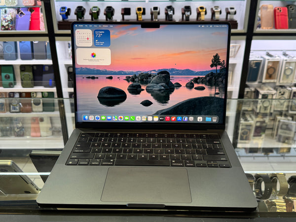 Laptop on display with a scenic wallpaper in a store setting