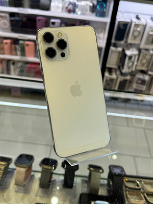 Gold iPhone with Apple logo on a reflective surface with blurred store background