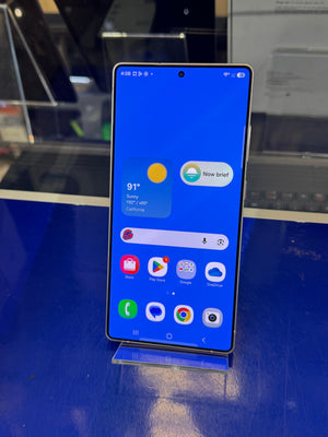 Smartphone displaying a blue screen with app icons on a reflective surface