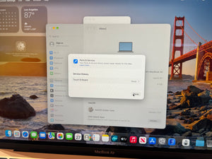 A close-up of a MacBook Air screen showing the macOS System Settings interface, with the 'Parties & Service' service history dialog box open. The background desktop wallpaper features a scenic view of the Golden Gate Bridge over water, and the 'MacBook Air' logo is visible at the bottom of the screen.