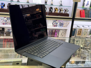 Laptop on display with a blurred store interior in the background