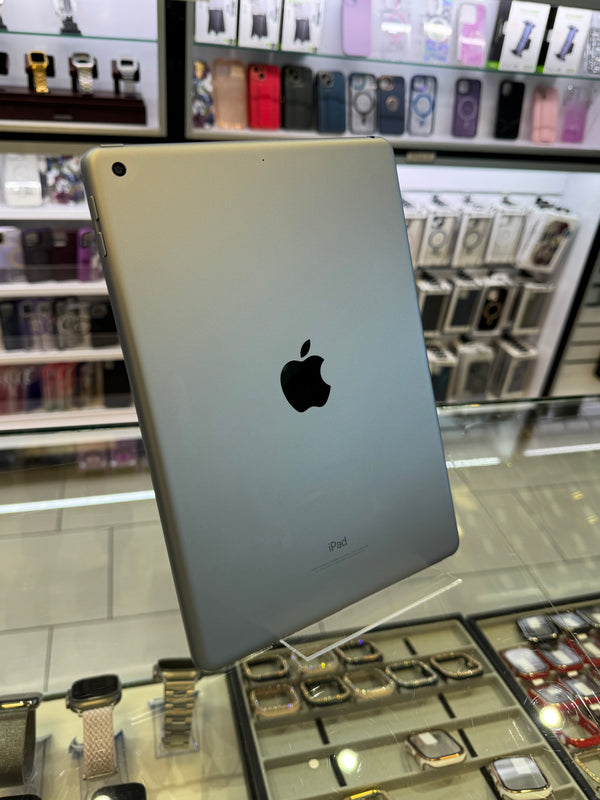 Silver Apple iPad on display in a store with various products in the background