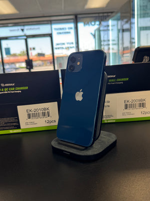 A blue Apple iPhone stands upright on a dark charging dock on a black tabletop, with two black and green ESOULK car charger boxes behind it in a retail or showroom setting.