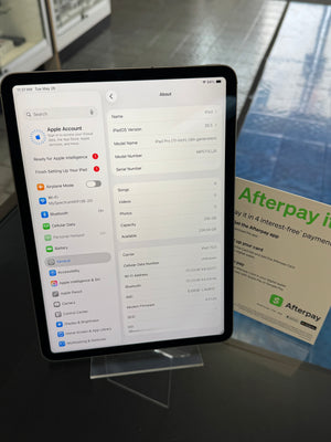iPad displaying settings on a stand with an Afterpay advertisement in the background