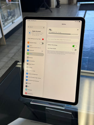 Tablet displaying a settings menu on a stand with a blurred background
