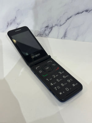 A black Alcatel flip phone with a physical keypad, shown open on a white surface with a white and gray marble-patterned background.