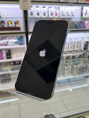 Black smartphone with Apple logo on a clear stand in a store setting
