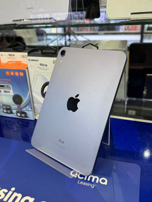 Silver iPad on a blue surface with blurred background