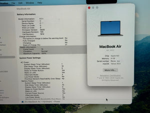 Technical specifications of a MacBook Air displayed on a screen with a scenic background.