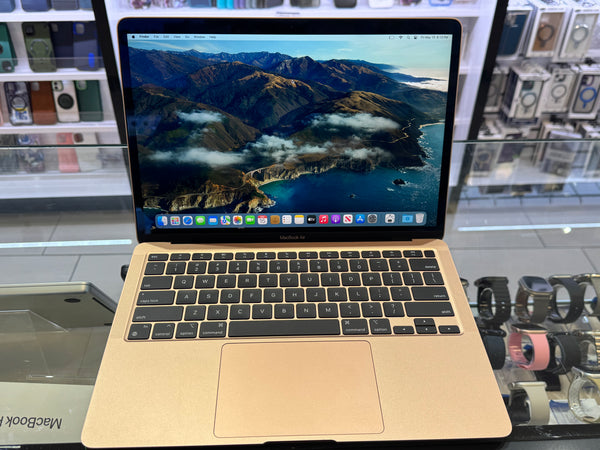Gold MacBook Pro laptop with mountainous landscape on screen in a store setting