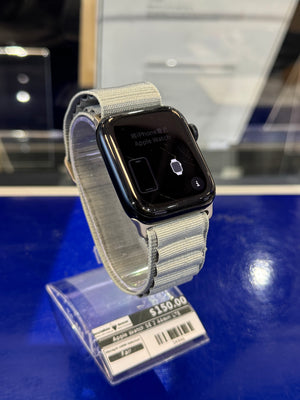 Smartwatch with a gray band on a blue surface, price tag visible