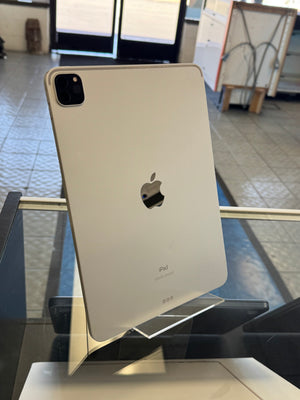 Silver Apple iPad Pro on a glass table with blurred background