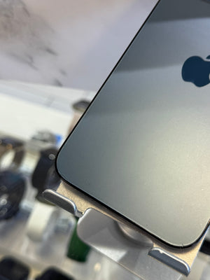 Close-up of the back of a silver Apple iPhone mounted on a display stand, showing the reflective aluminum finish and part of the black Apple logo.