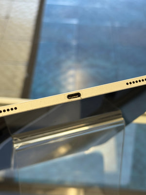 Close-up of a metallic surface with a USB-C port on a reflective background