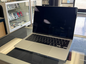 Laptop on a glass surface with a store interior in the background