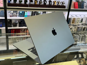 Apple laptop on display in a store with shelves in the background