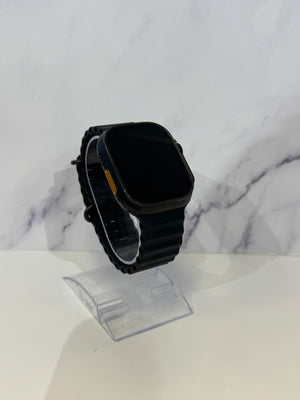 A black smartwatch with a rectangular rounded-rectangle face and matching black strap, displayed on a clear stand against a white marble-patterned background.