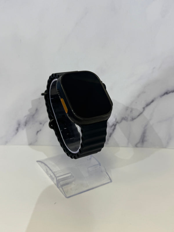 A black smartwatch with a rectangular rounded-rectangle face and matching black strap, displayed on a clear stand against a white marble-patterned background.