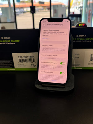 A smartphone on a black charging stand displaying battery health and charging settings, with two black ESOULK QC 3A car charger boxes in the background.