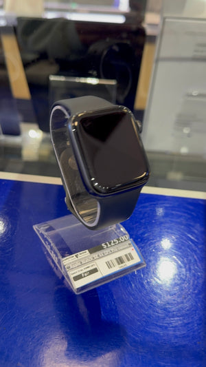 Black smartwatch on a blue display stand with a price tag.
