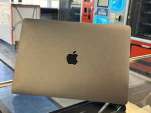 Apple laptop with Apple logo on a reflective surface