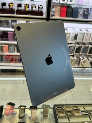Back view of an iPad on display in a store with various phone cases in the background.