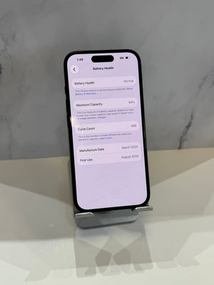 A black smartphone displayed upright on a small stand on a white surface, with a light gray marble-patterned background. The phone screen shows the Battery Health settings page.