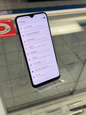 Smartphone with a screen displaying a settings menu on a glass surface