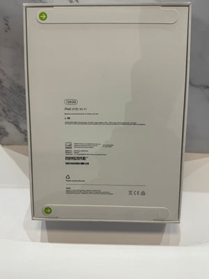 The back of a white Apple iPad box, showing product specifications, barcodes, and recycling symbols on a white surface.